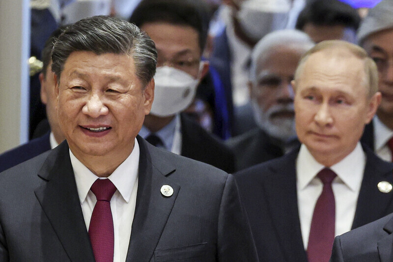 President Xi Jinping of China (left) and President Vladimir Putin of Russia (right) enter the meeting hall at the Shanghai Cooperation Organisation in Uzbekistan one after the other on Sept. 16. (AP/Yonhap)