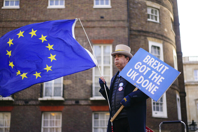 A person in downtown London carries an EU flag and a sign opposing Brexit on Jan. 9, 2023. (AP/Yonhap)