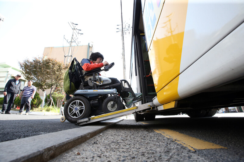 2016년 4월15일 오후 한 지방의 버스정류장에서 전동휠체어를 탄 장애인이 저상버스에 오르고 있다. 연합뉴스