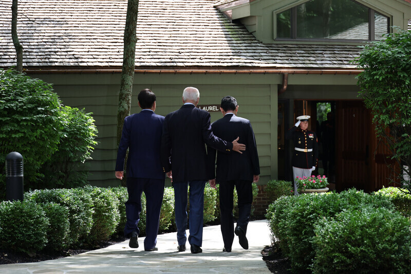 South Korean President Yoon Suk-yeol, US President Joe Biden, and Japanese Prime Minister Fumio Kishida head into their summit at Camp David in Maryland on Aug. 18 after taking photos together. (Yonhap)