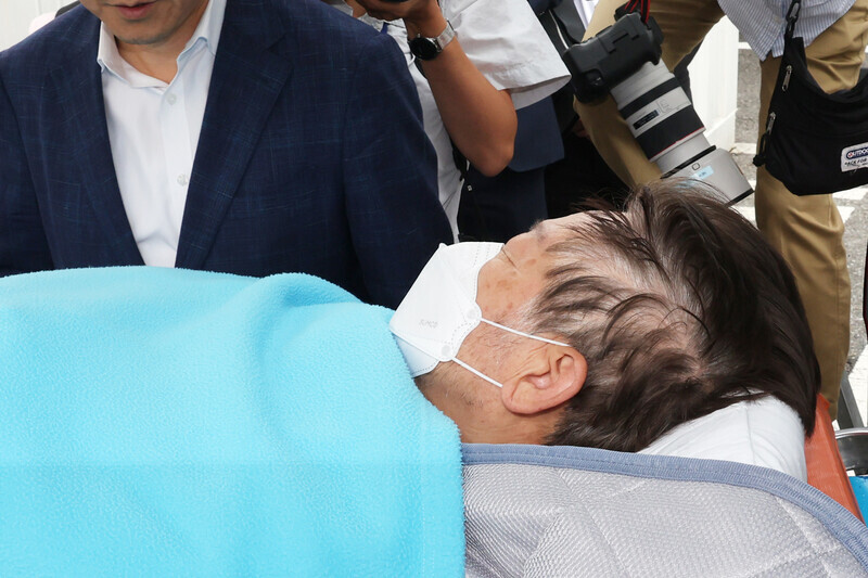 Lee Jae-myung, the leader of Korea’s main opposition Democratic Party, is lifted into an ambulance on Sept. 18 to be transferred to Green Hospital in Seoul’s Jungnang District after receiving emergency medical attention at the Catholic University of Korea Yeouido St. Mary’s Hospital. (Yonhap)
