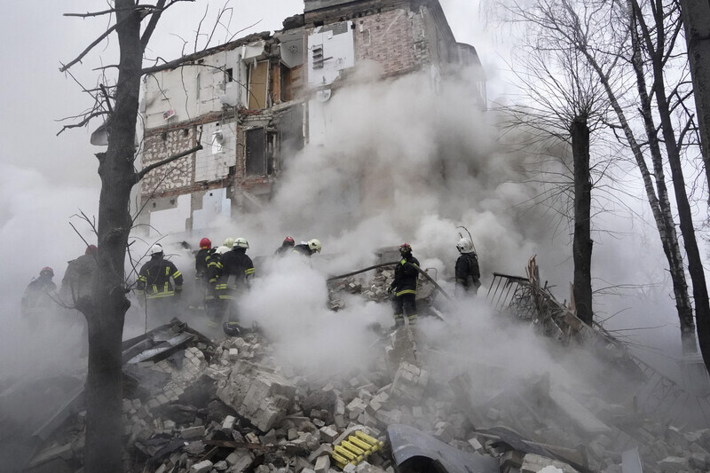 Rescue workers search through dust and rubble after a Russian air strike hit a building in Kharkiv, Ukraine, on Jan. 23. (AP/Yonhap)