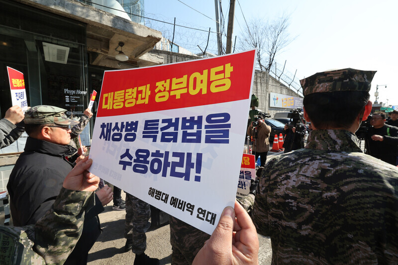 A person with a group of Marine reservists holds up a sign calling for the government and ruling party to allow a special prosecutor investigation into the death of a Marine. (Kim Hye-yun/The Hankyoreh)