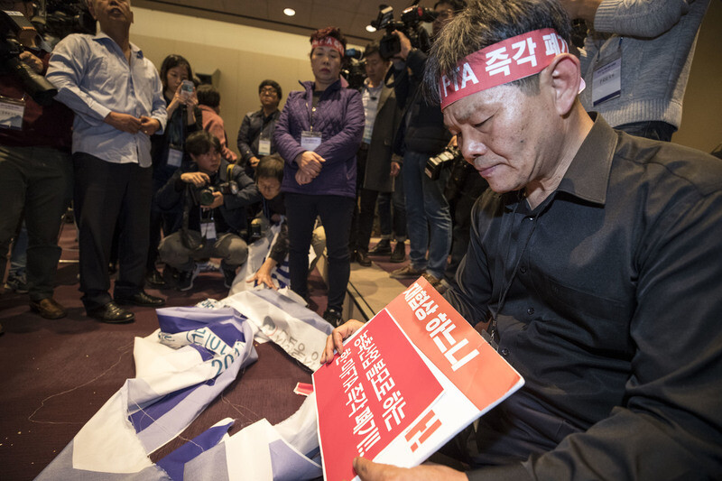 Farmers including Moon Jung-jin of the Korean National Chicken Association urge officials from the Ministry of Trade