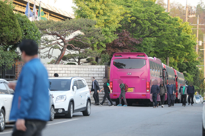 Nightshift workers disembark a bus and head to work at a factory in Ansan