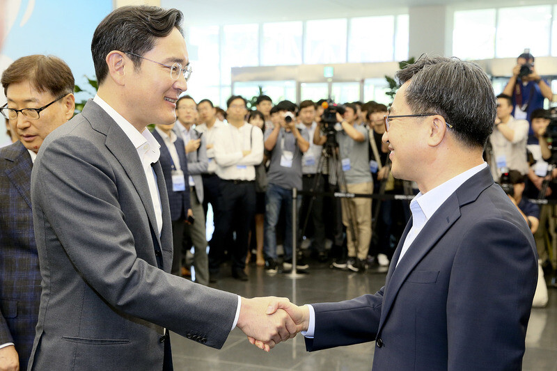 Deputy Prime Minister and Minister of Economy and Finance Kim Dong-yeon (right) and Samsung Electronics Vice Chairman Lee Jae-yong shake hands after a meeting at a Samsung semiconductor plant in Pyeongtaek