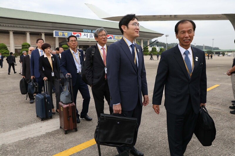 South Korean chaebol chairmen and business figures walk to board the plane to Pyongyang Sep. 18.