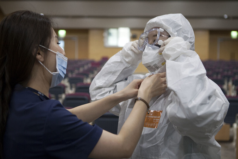 A medical worker at Seoul Medical Center puts on a protective suit before tending to COVID-19 patients. (Yonhap News)