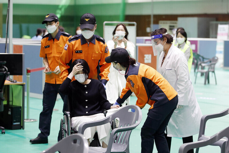 Health workers, paramedics and a woman carry out a COVID-19 vaccination dry-run Wednesday at a vaccination site in Gwangju Buk (North) District Athletic Center. (Yonhap News)