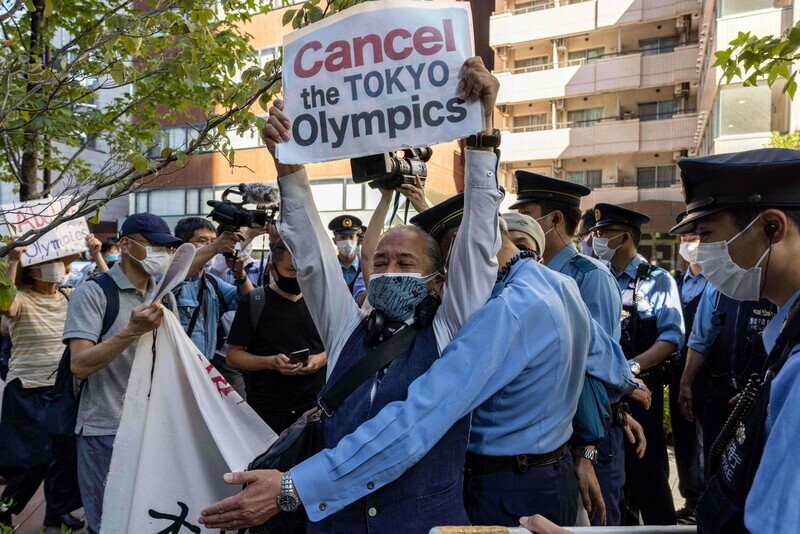 Japanese police stop protesters attempting to enter the hotel where International Olympic Committee President Thomas Bach is staying in Tokyo on Saturday. (AFP/Yonhap News)