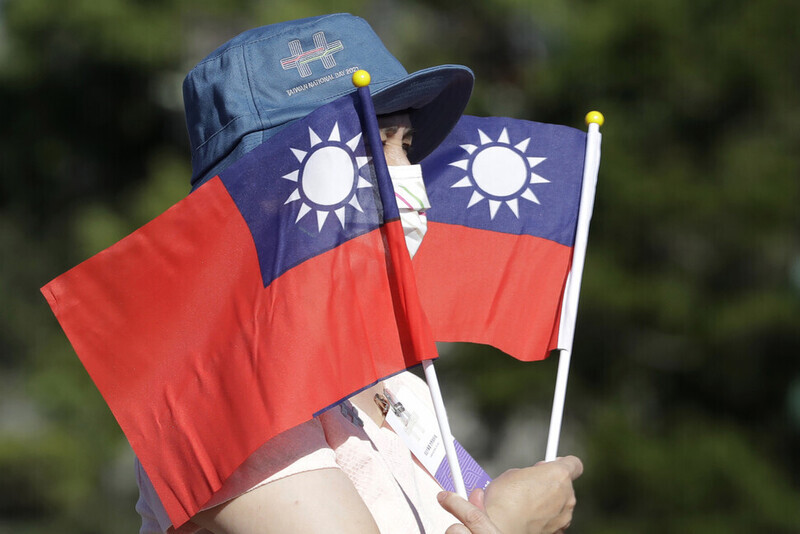 A person holds up two Taiwanese flags during an event marking Taiwan National Day on Oct. 10, 2021, in Taipei. (AP/Yonhap News)