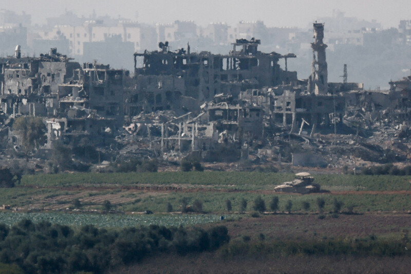 6일 팔레스타인 가자지구에서 뼈대만 남은 건물 앞으로 탱크 한 대가 지나가고 있다. 로이터 연합뉴스