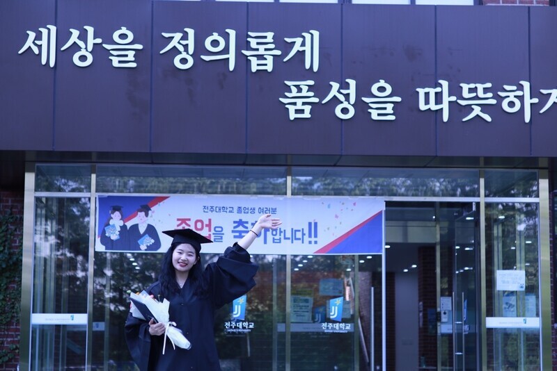 Sun Huiling, an international student from China, poses for a photo in her graduation gown and cap after her graduation from Jeonju University in 2022. (courtesy of Sun)