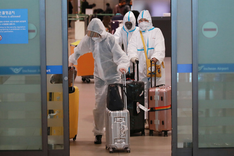 Passengers in protective suits arrive at Incheon International Airport from Qingdao, China, on Apr. 3. (Yonhap News)