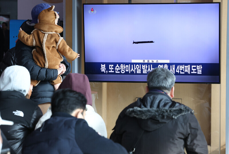 Travelers in Seoul Station watch news coverage of a North Korean missile launch playing on TV monitors on Feb. 2. (Yonhap)