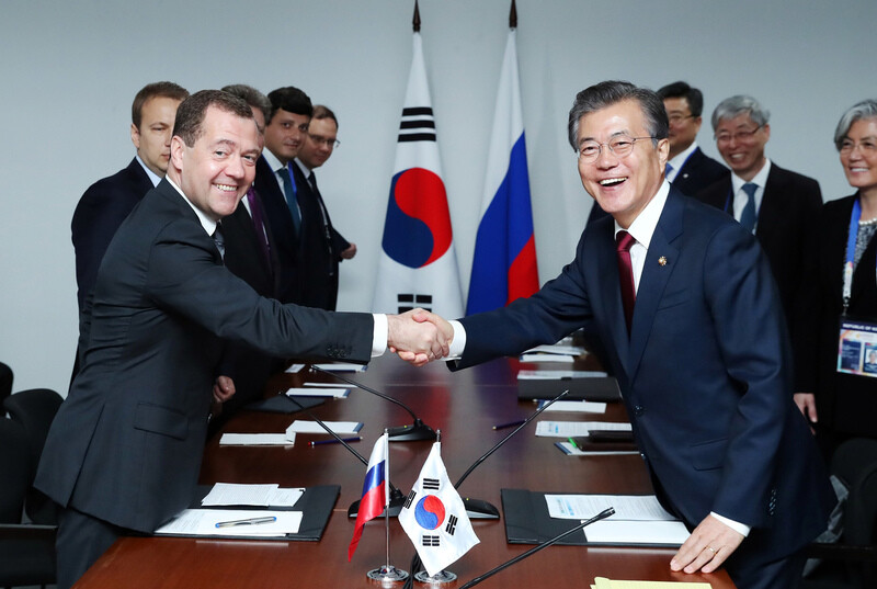 South Korean President Moon Jae-in shakes hands with Russian Prime Minister Dmitry Medvedev during their summit in Manila