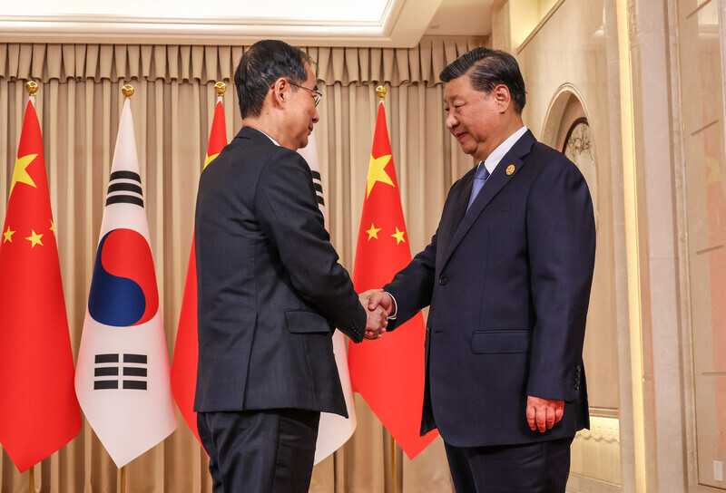 South Korean Prime Minister Han Duck-soo (left) shakes hands with Chinese President Xi Jinping while visiting the city of Hangzhou to attend the opening ceremony of the Asian Games being held there. (courtesy of the prime minister’s office)