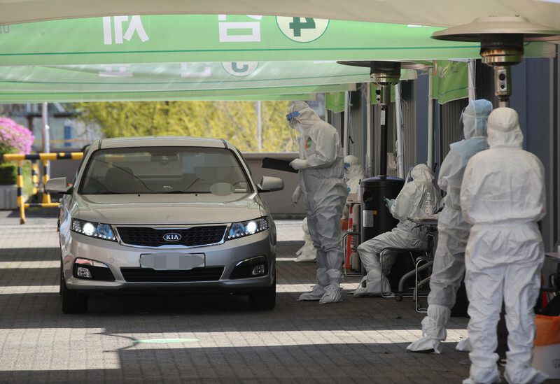 Medical workers at a drive-thru screening center in the parking lot of Seoul Sports Complex on Apr. 13. (Yonhap News)