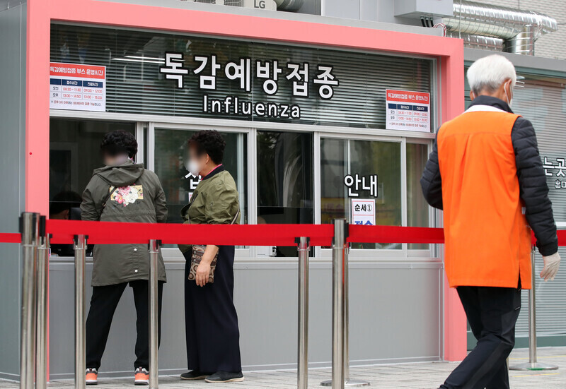 People wait to receive a flu vaccination in Seoul on Oct. 27. (Yonhap News)