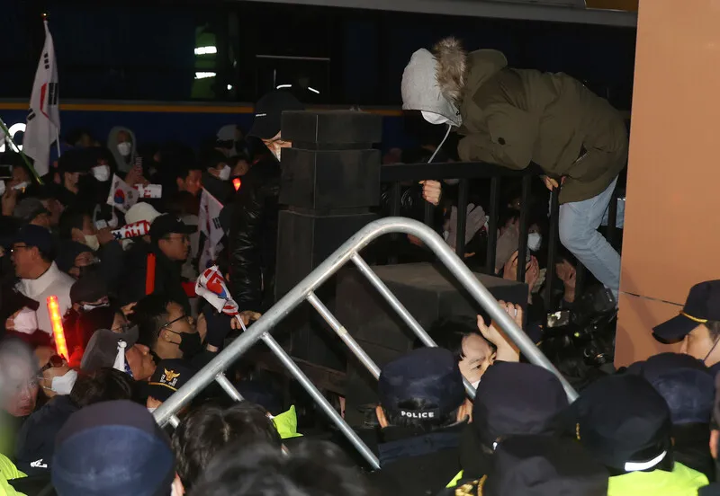 18일 오후 서울 마포구 서울서부지법에서 '내란우두머리' 혐의 등으로 체포된 윤석열 대통령의 영장실질심사가 진행되고 있는 가운데, 윤 대통령 지지자들이 법원 담장을 넘어왔다가 다시 밖으로 나가고 있다. 공동취재사진