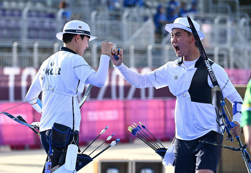 양궁 국가대표 김제덕(오른쪽)이 7월24일 일본 도쿄 유메노시마 공원 양궁장에서 열린 도쿄올림픽 혼성 단체전 결승전에서 10점을 쏜 뒤 안산과 주먹을 맞대며 “파이팅”을 외치고 있다. 도쿄/올림픽사진공동취재단