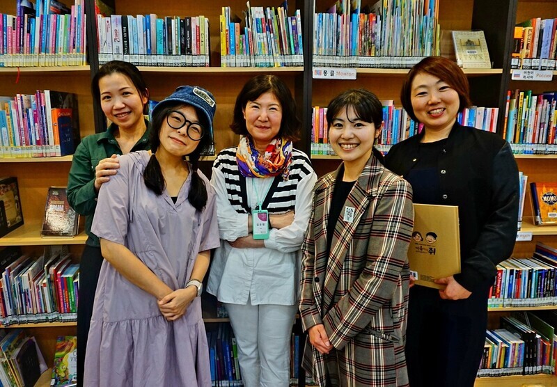 The migrant women who manage the Geumchon Rainbow Small Library pose for a photo on May 9, 2024. From left to right are Jeon Yiru, Gan Gahye, librarian Kim Eun-yeong, Yurie Nikami, and Sayaka Iizuka. (Lee Jun-hee/The Hankyoreh)