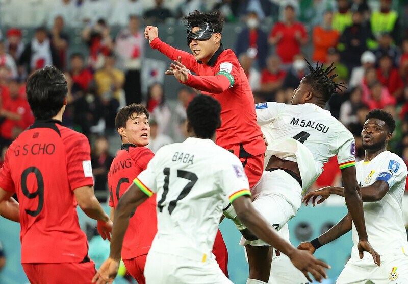 Son Heung-min, the striker on Korea’s national football team, attempts a header while wearing a mask due to an injury, during the team’s match against Ghana on Nov. 28 (Korea time) in Education City Stadium in Al Rayyan, Qatar. (Yonhap)