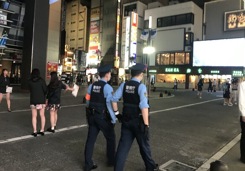 Two Japanese police officers patrol the Kabukicho area in Tokyo on Tuesday around 9 pm. (Lee Jun-hee/The Hankyoreh)