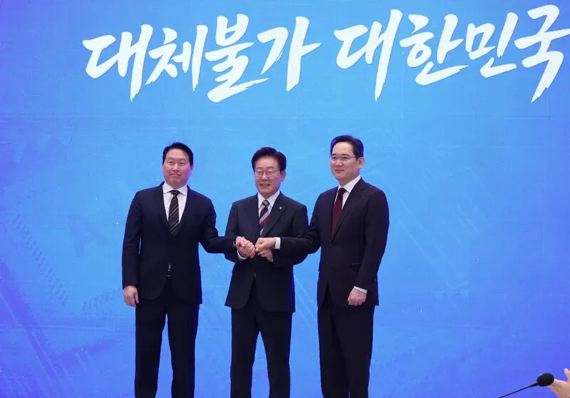President Lee Jae Myung (center) joins hands with SK Group Chairman Chey Tae-won and Samsung Electronics Chairman Lee Jae-yong at an announcement of three &ldquo;megaprojects&rdquo; from the Blue House on June 29, 2026. (pool photo)