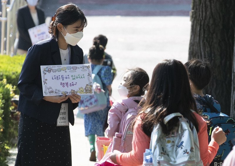 Teachers at an elementary school in Seoul’s Songpa District welcome students on their first day back to school on May 27. (Yonhap News)
