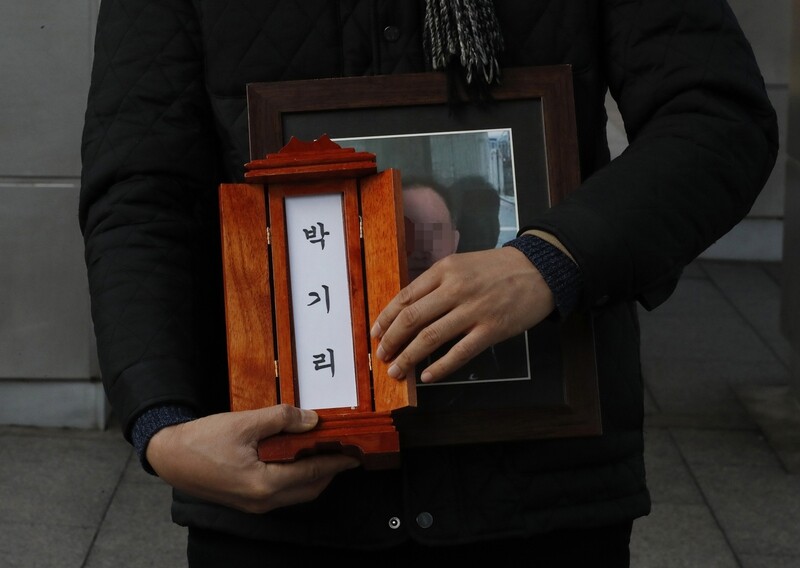  holds the handphone of Park Gi-ri displaying his picture on Feb. 17. Park left behind the phone when he died a lonely death in the Eunpyeong district of Seoul.
