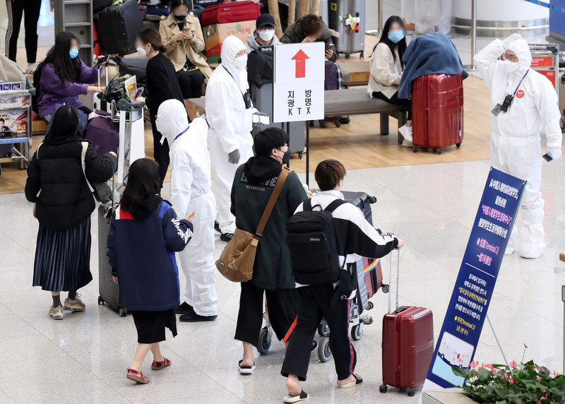 Travelers arriving at Incheon International Airport from Europe follow instructions from quarantine workers on Mar. 29. (Yonhap News)