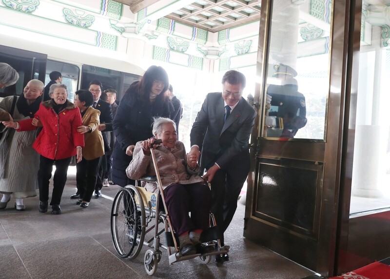 President Moon Jae-in provides an escort to comfort woman survivor Kwak Yea-nam into the reception room of the Blue House on Jan. 4. (provided by Blue House)
