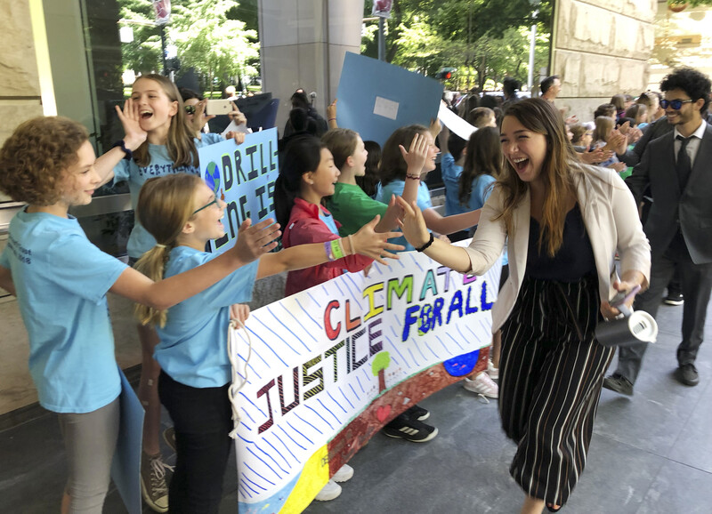 미국 정부의 에너지 정책이 자신의 미래를 어렵게 하고 있다며 정부를 상대로 소송을 제기한 켈시 줄리아나(가운데)가 2019년 6월4일 청소년들과 손뼉을 맞추고 있다. AP/연합뉴스