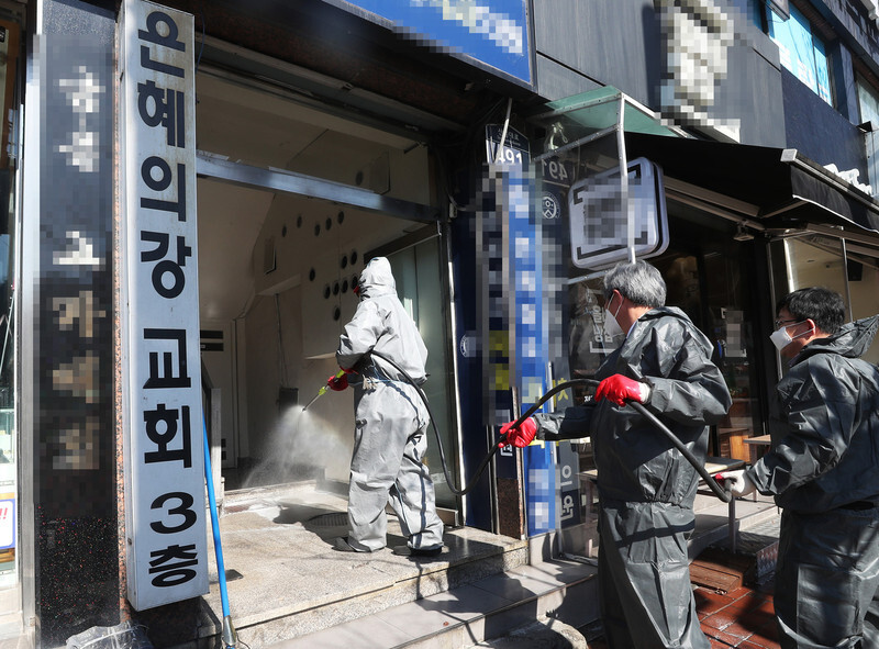 Sanitation workers disinfect the River of Grace Community Church in Seongnam, Gyeonggi Province, where a transmission cluster of 46 novel coronavirus patients was confirmed, on Mar. 16. (Yonhap News)