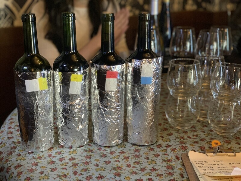 Bottles of wine with their labels covered.