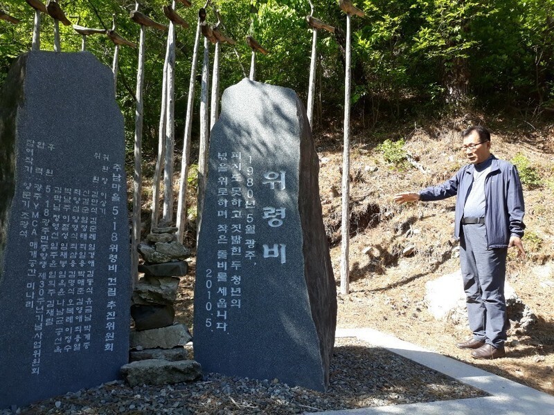 Chung Su-man, former chair of an organization for families who lost loved ones during the Gwangju Uprising, looks over the commemorative stone honoring the victims of the Junam Village mass shooting on May 23, 1980. (Jung Dae-ha/The Hankyoreh)