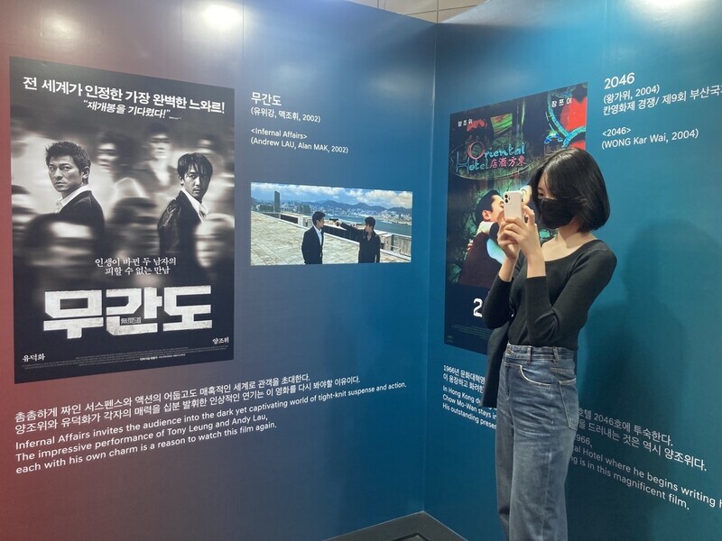 A young person snaps a photo at an exhibit on Tony Leung’s career at BIFF. (Park Mi-hyang/The Hankyoreh)