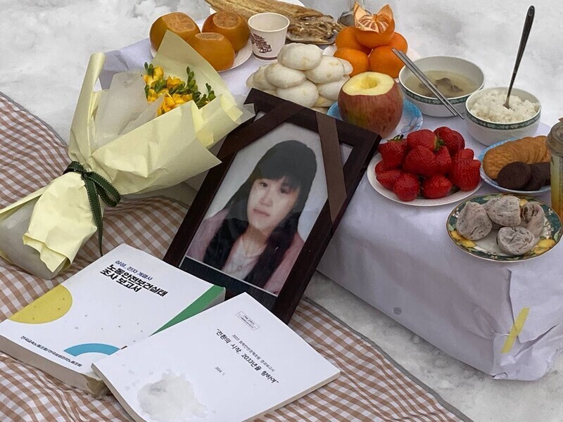 A copy of a recently published report on worker safety and health conditions at Samsung’s electronics-producing affiliates sits in front of the memorial portrait of Hwang Yu-mi, who died of leukemia while working at a Samsung semiconductor plant, during a memorial ceremony held on March 3, 2024, in Sokcho, Gangwon Province. (courtesy of Lee Jong-ran)