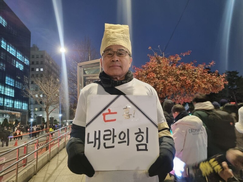 13일 저녁 6시 서울 영등포구 국회의사당역 앞에서 열린 ‘내란수괴 윤석열 즉각 탄핵! 시민촛불’ 집회에 장례 복장을 한 조삼호(68)씨가 ‘내란의힘’이란 팻말을 목에 걸고 있다. 박고은 기자