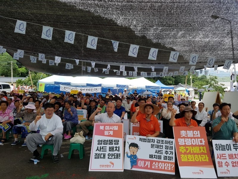 Demonstrators chant “THAAD must go for peace to come” during a rally outside the community center in Soseong Village