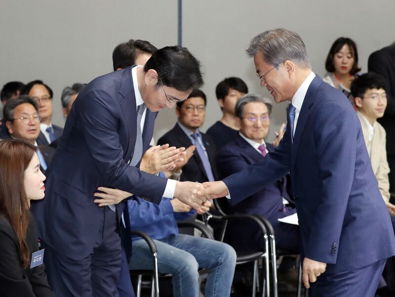 South Korean President Moon Jae-in shakes hands with Samsung Electronics Vice Chairman Lee Jae-yong at a production plant in Hwaseong