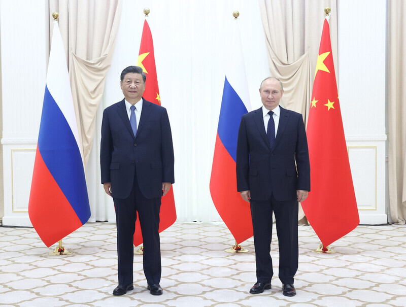 Chinese President Xi Jinping (left) and Russian President Vladimir Putin stand for a photo on the sidelines of the Shanghai Cooperation Organisation summit in Uzbekistan on Sept. 15. (Xinhua/Yonhap)