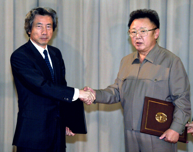 Then-Japanese Prime Minister Junichiro Koizumi and then-North Korean leader Kim Jong-il shake hands during their meeting in Pyongyang in September 2020. (pool photo)