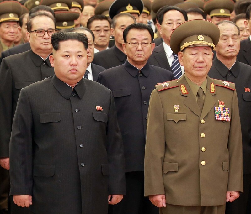 North Korean leader Kim Jong-un stands next to Hwang Pyong-so