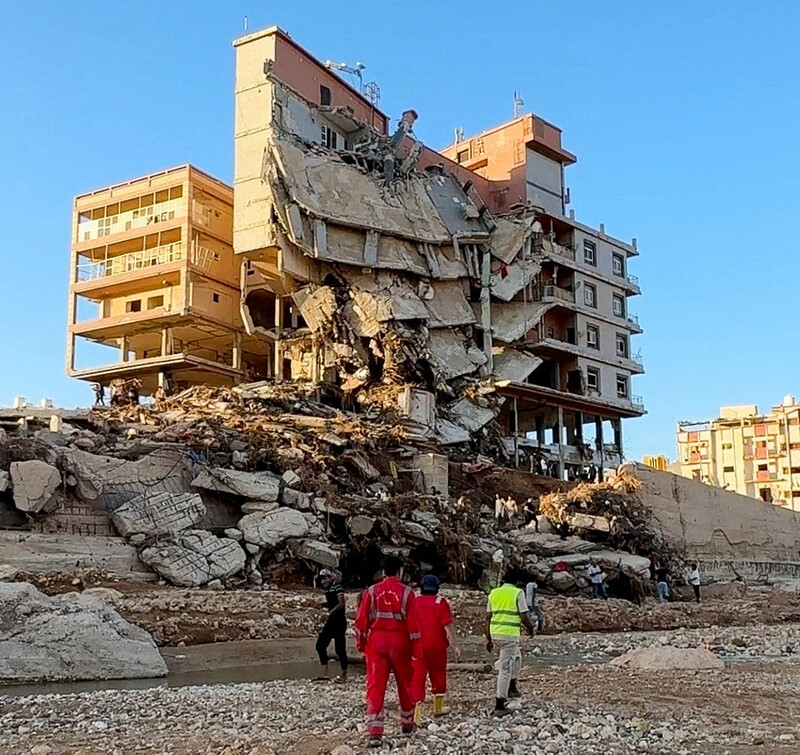 12일(현지시각) 리비아 데르나시에서 폭우로 인한 피해로 부서진 건물 앞에서 구조대원들이 작업을 하고 있다. 로이터 연합뉴스