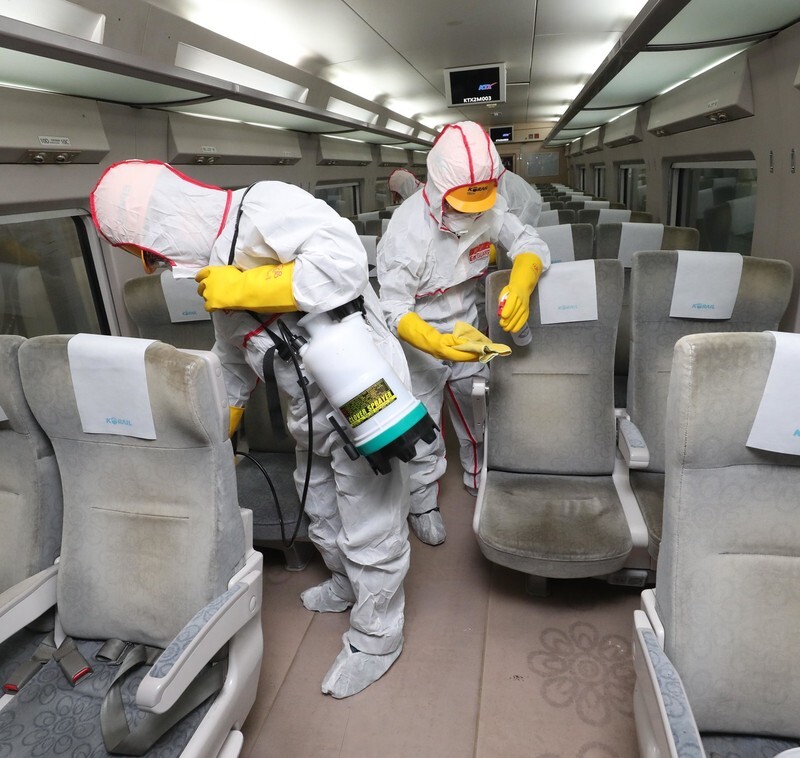 Workers sanitize a KTX train in Goyang, Gyeonggi Province, on Feb. 6. (Kang Chang-kwang, staff photographer)