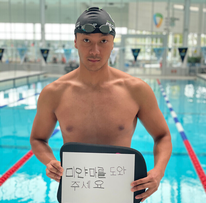 Win Htet Oo, a 26-year-old swimmer on Myanmar’s national team, poses for a picture while holding a sign that reads “help Myanmar.” (provided by Win Htet Oo)