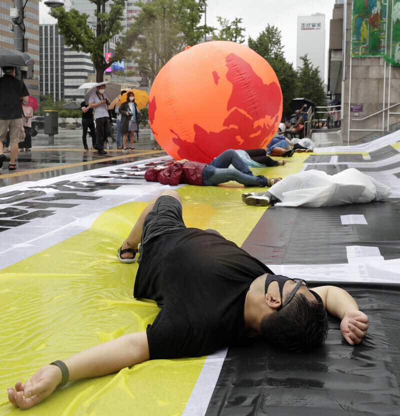 Demonstrators call for government action on climate change through a performative protest in front of the Sejong Center for the Performing Arts in Seoul on Sept. 2. (Kim Hye-yun, staff photographer)