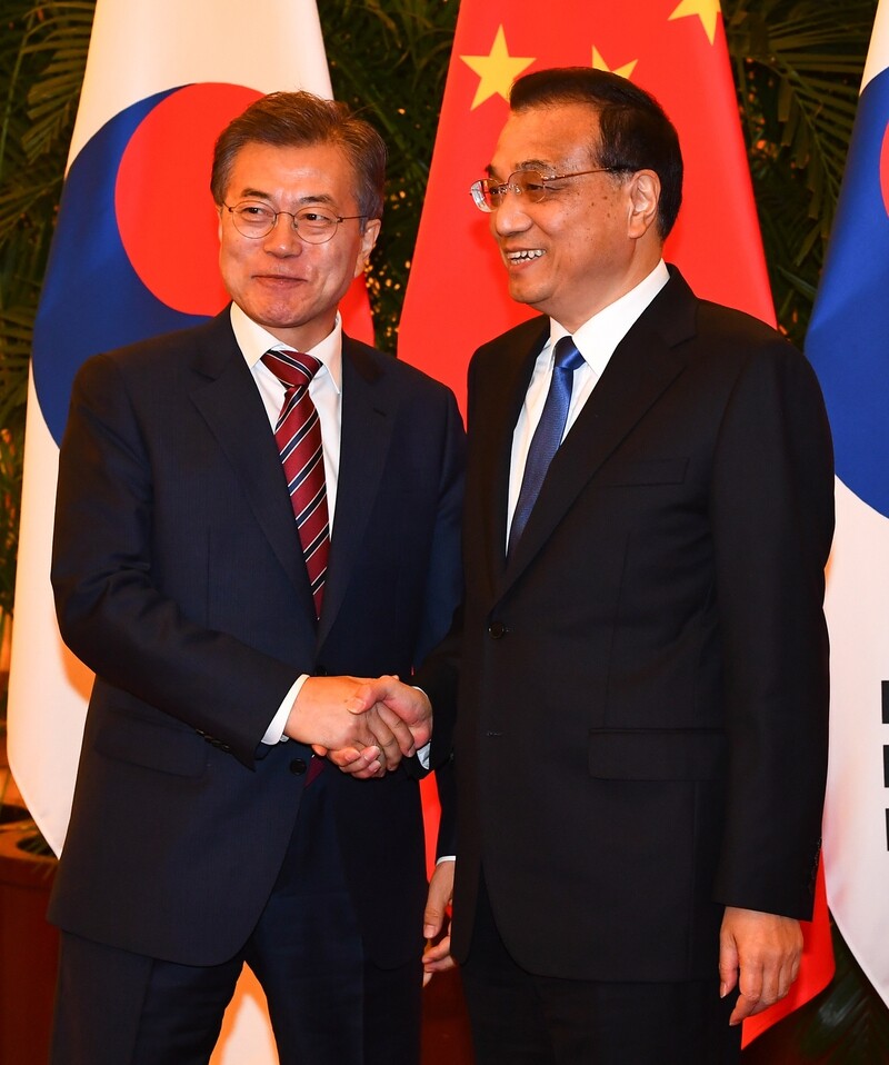 South Korean President Moon Jae-in shakes hands with Chinese Premier Li Keqiang at the Great Hall of the People in Beijing on Dec. 15. (Yonhap News)